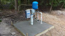 A completed well site with a 5x5 concrete pad